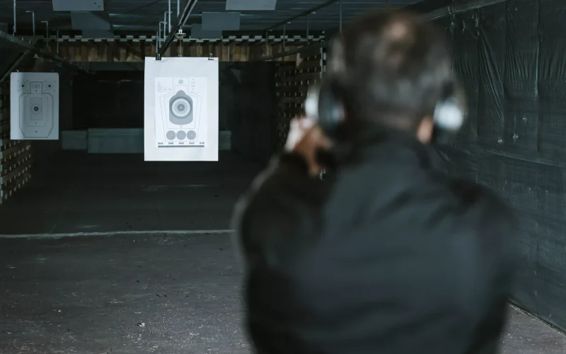 _rear-view-of-man-aiming-gun-at-target-in-shooting